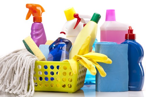 Cleaner wiping communal touchpoints in a hallway and entrance space